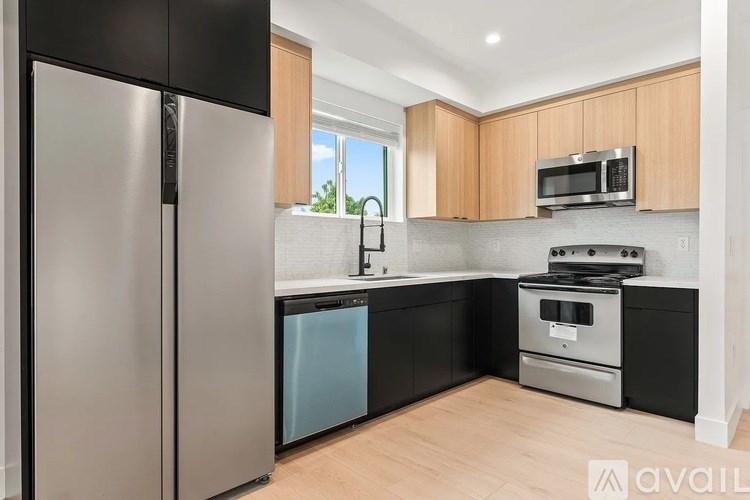 A modern kitchen with a stainless steel refrigerator and wooden cabinets.