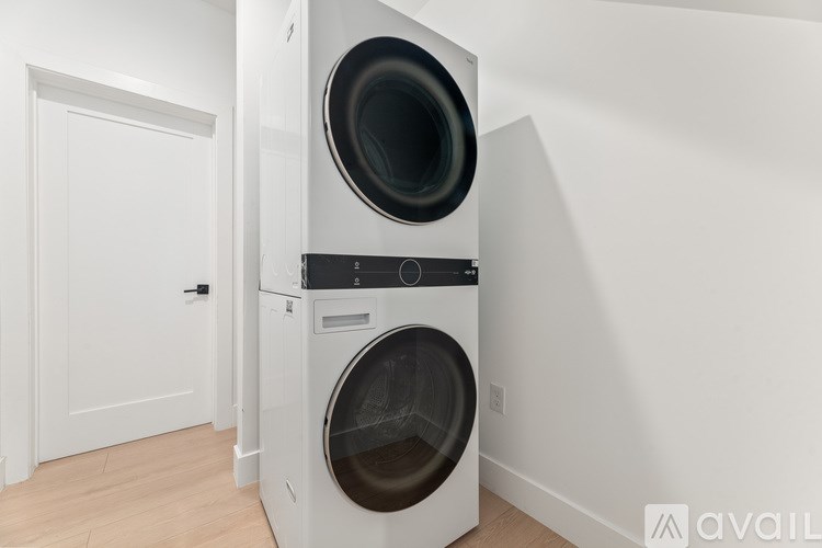 A white front loading washing machine in a laundry room.