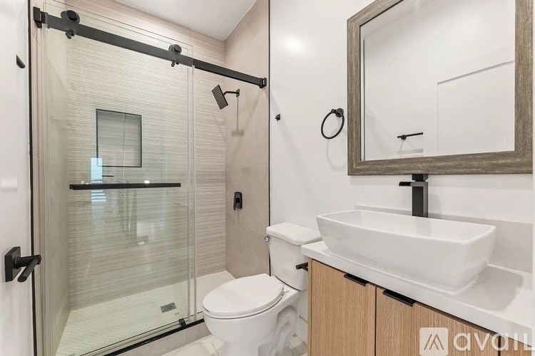 A modern bathroom with a toilet, sink, and shower.