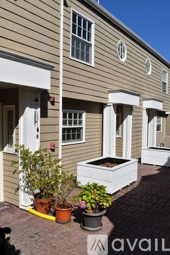 A house with a white door and windows is shown with a planter box in front.
