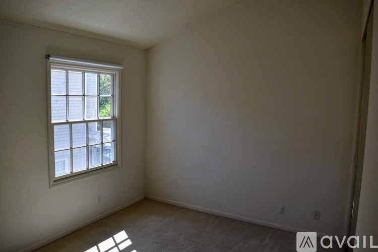A room with a window and a carpet floor.