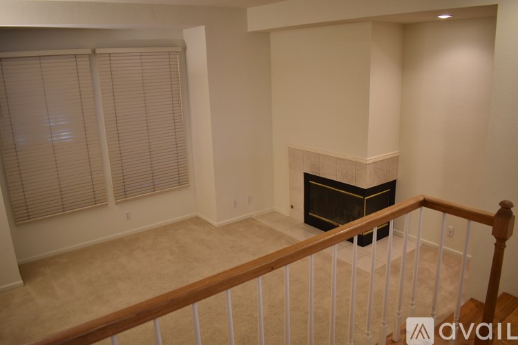 A living room with a fireplace and a staircase.