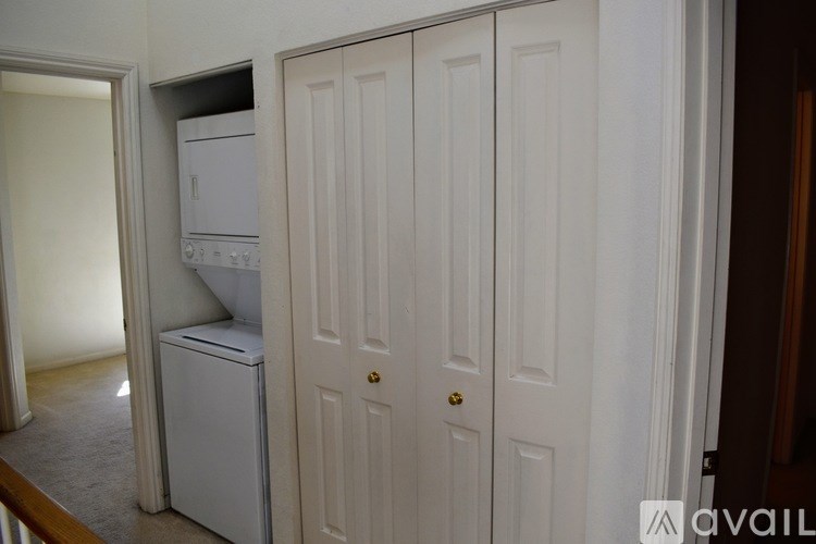 A white refrigerator is in a kitchen next to a white door.