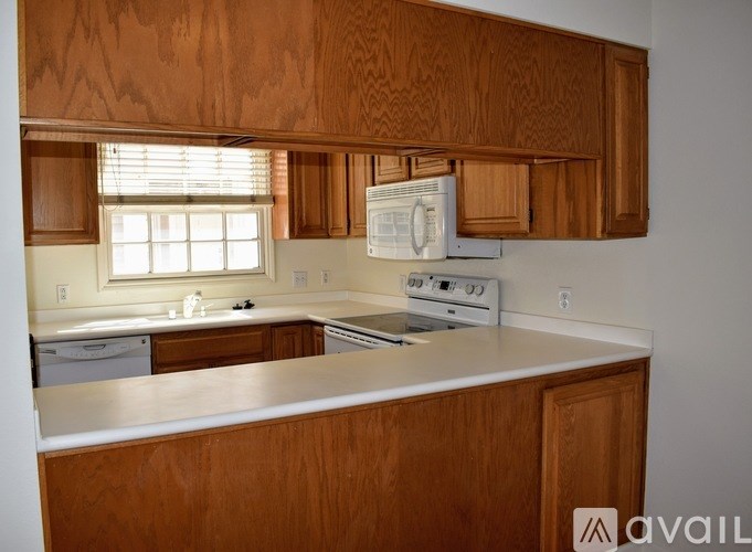 A kitchen with wooden cabinets and a white countertop.