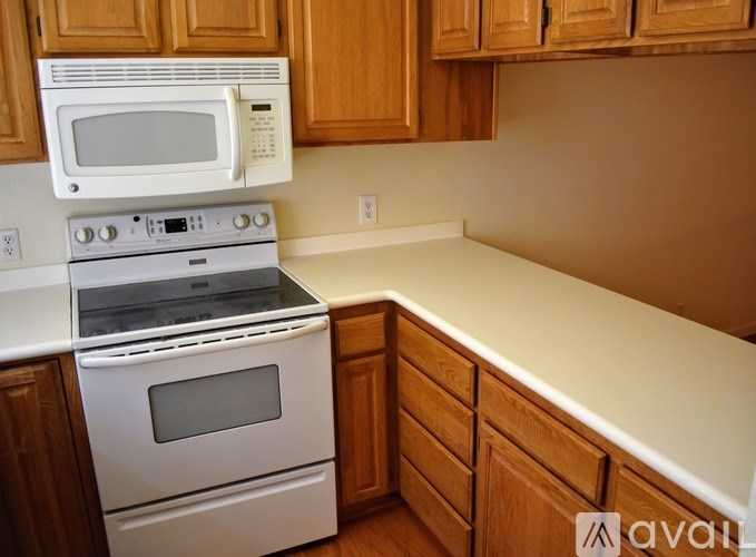 A kitchen with wooden cabinets and white appliances.
