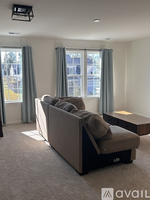 A living room with a grey couch and a television.