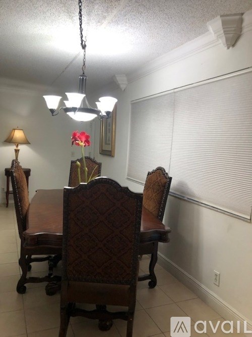 A dining room with a wooden table and chairs.