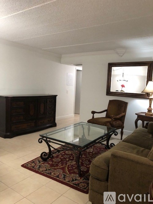 A living room with a glass coffee table and a brown chair.