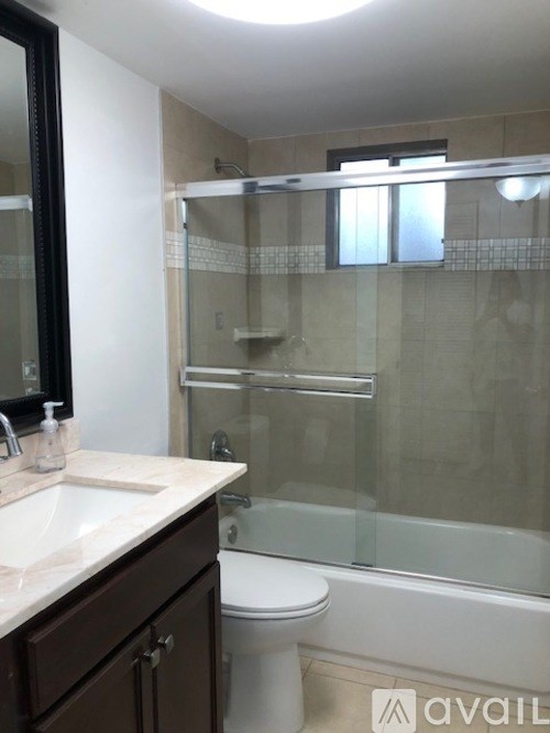 A bathroom with a toilet, sink, and shower.