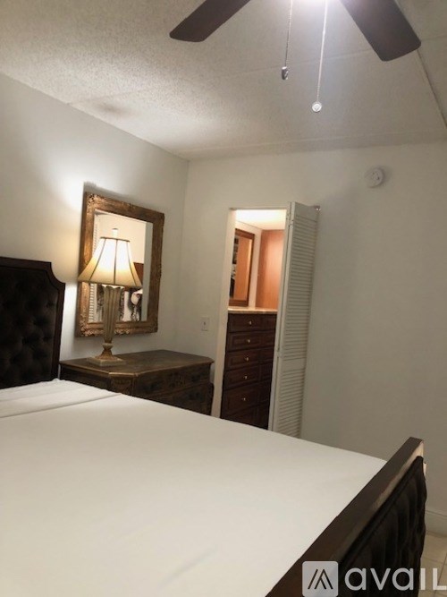 A bedroom with a bed, dresser, and mirror.