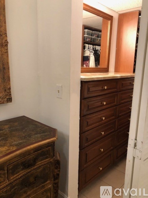 A brown dresser with a marble top is in a room.