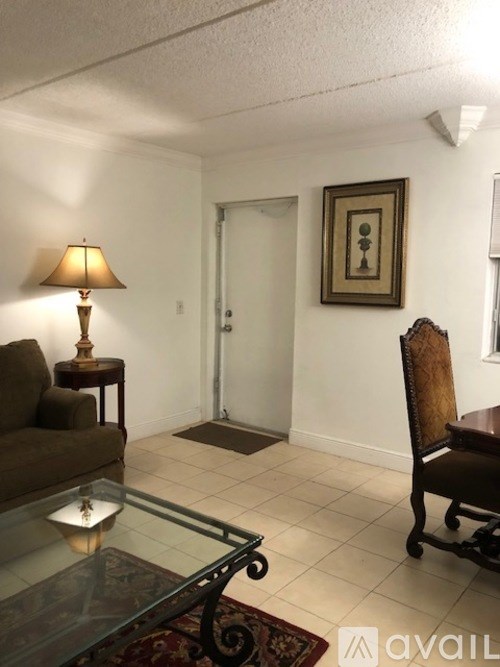 A living room with a couch, chair, lamp, and picture on the wall.