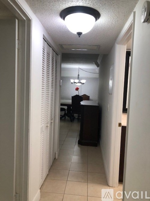 A hallway with a light on the ceiling and a door on the right.