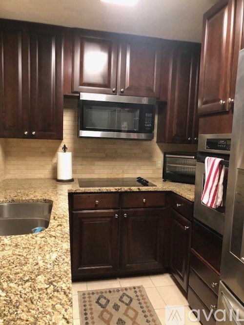 A kitchen with brown cabinets and a granite countertop.