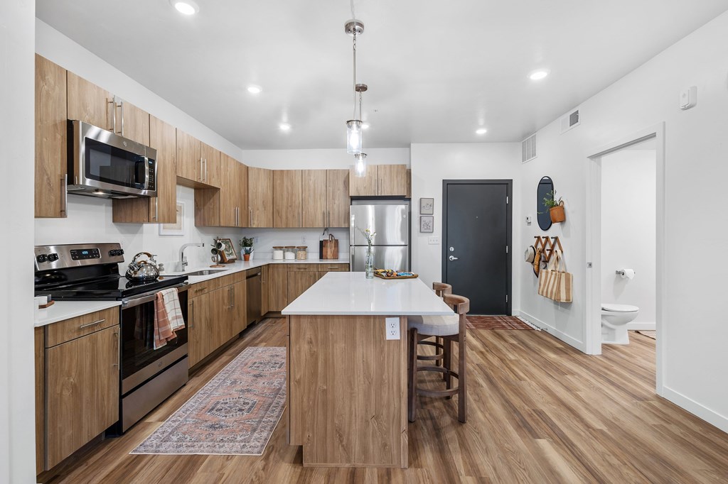 A kitchen with wooden cabinets and a white island.