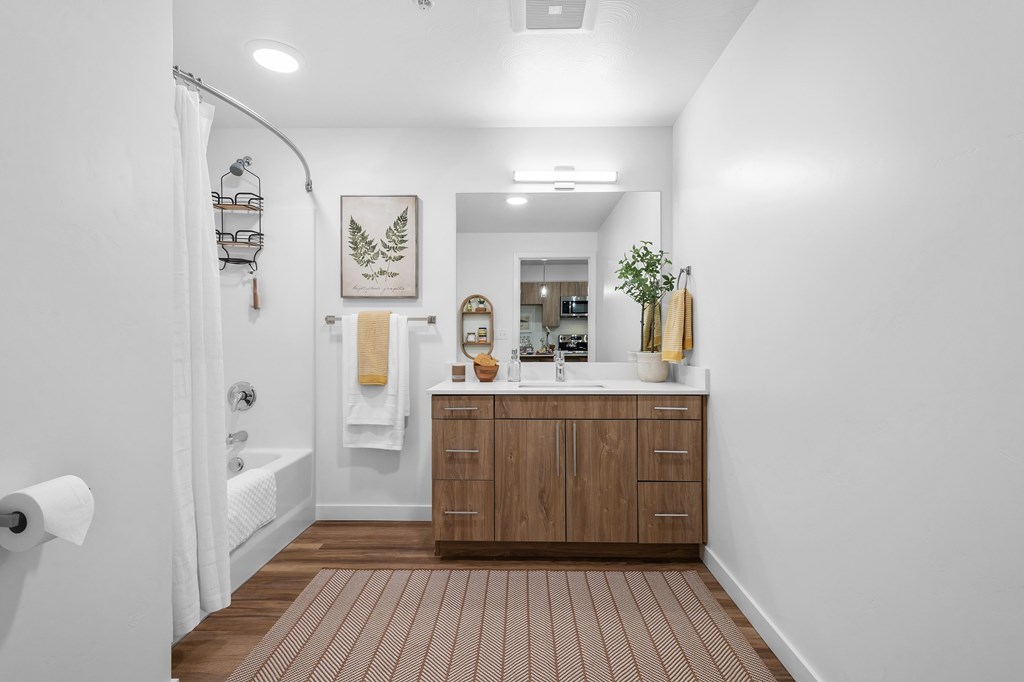 A bathroom with a wooden floor and white walls.