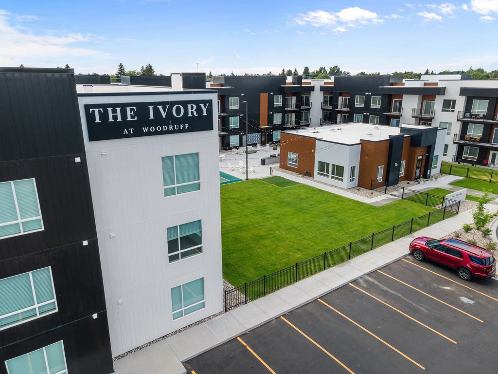 The Ivory at Woodruff is a modern apartment complex with a parking lot in front.