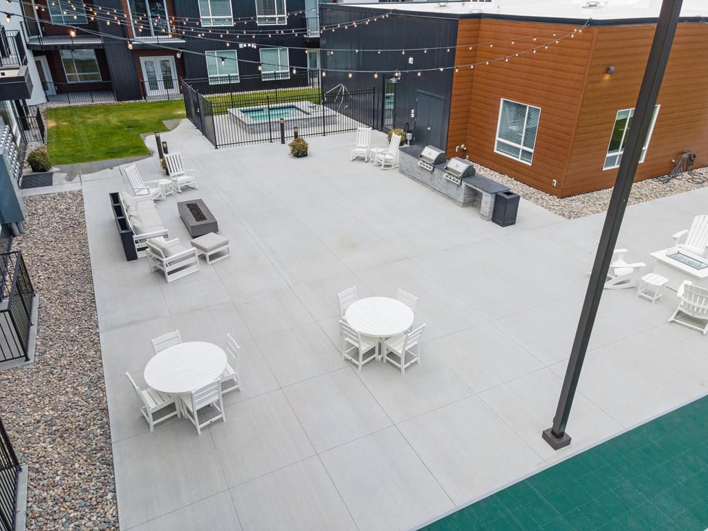 A patio with white furniture and a pool.