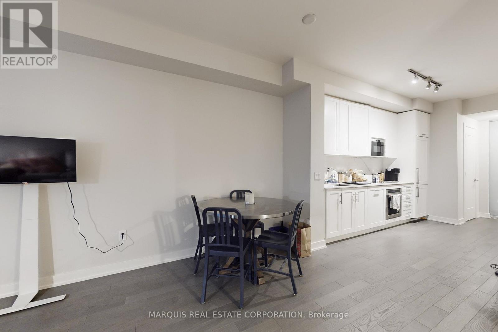 A kitchen with a dining table and chairs in the foreground.