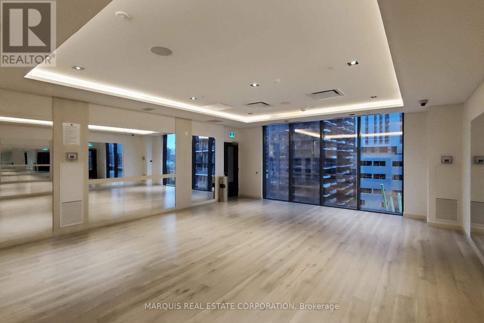 A spacious office with wooden floors and large windows.