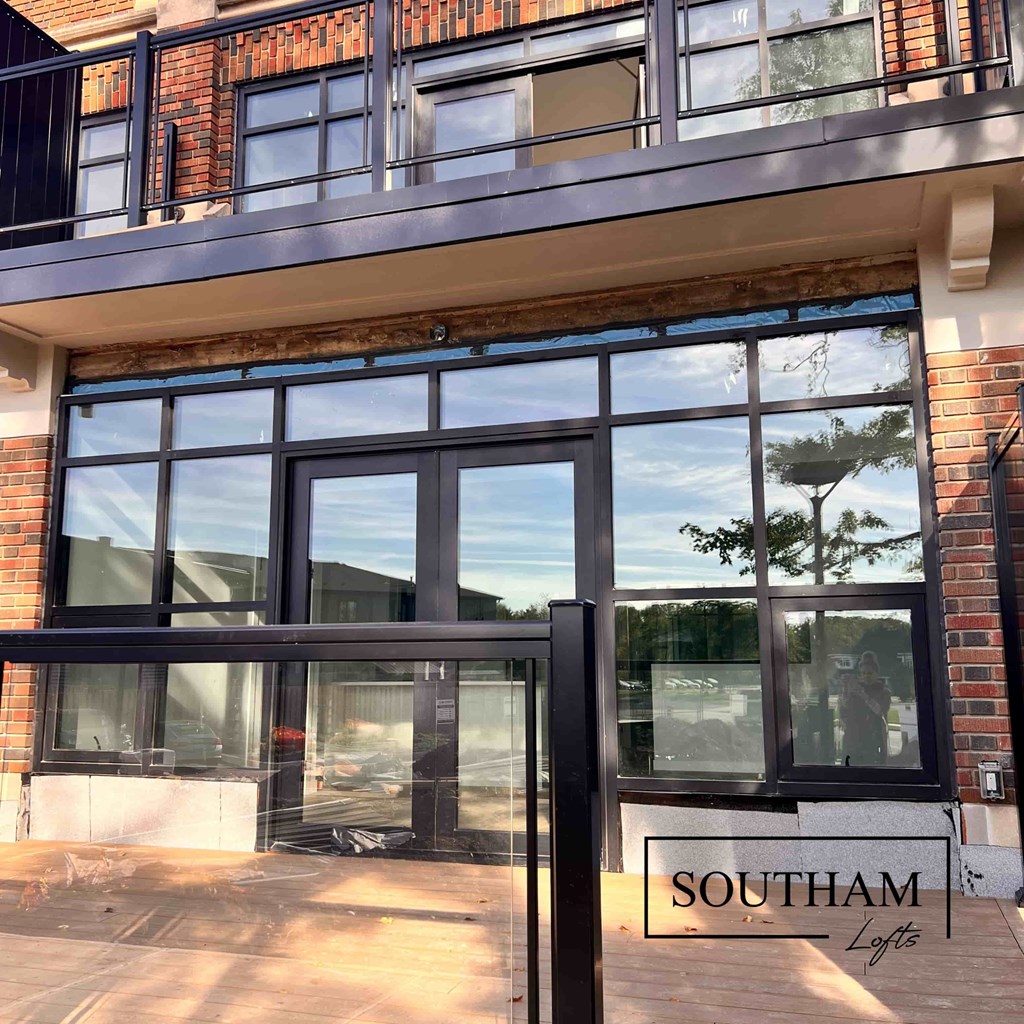 A modern building with a glass entrance and a sign that says "SOUTHAM Lofts".