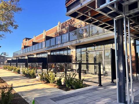 A modern building with a glass facade and a metal structure on the side.