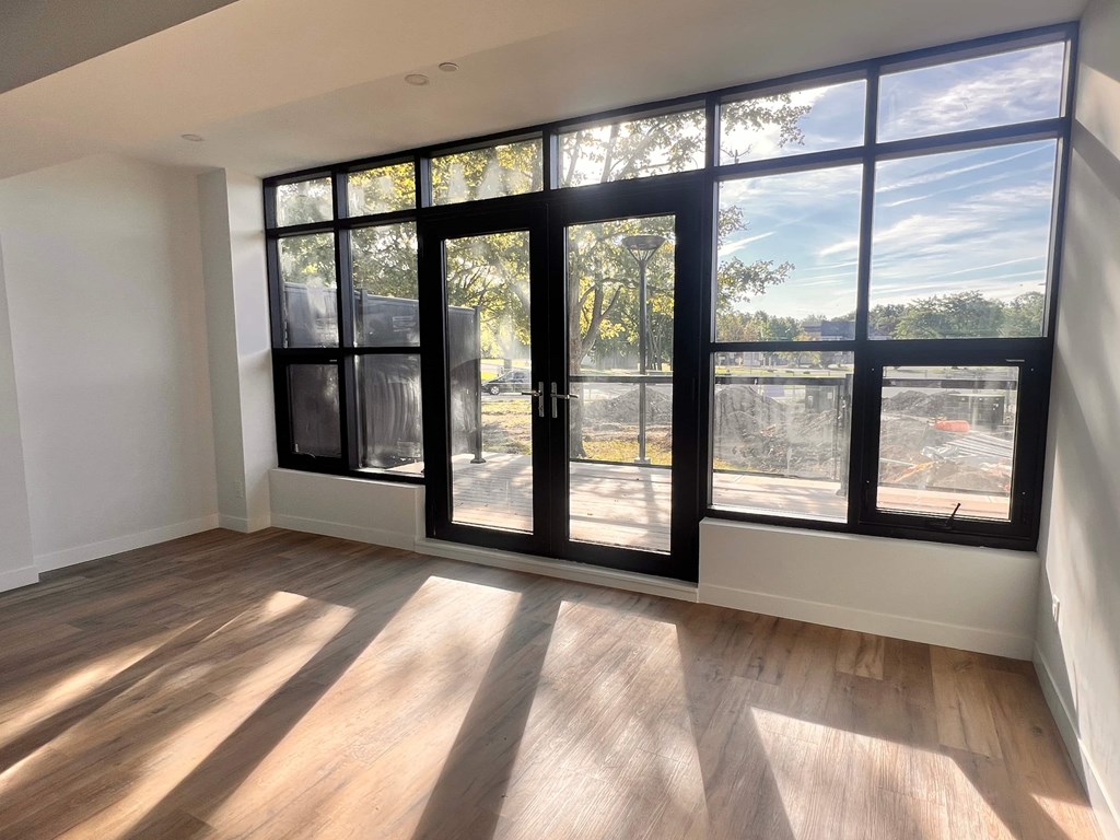 A room with a large window and wooden flooring.