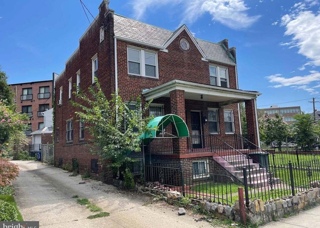 A red brick house with a green arched entrance gate.