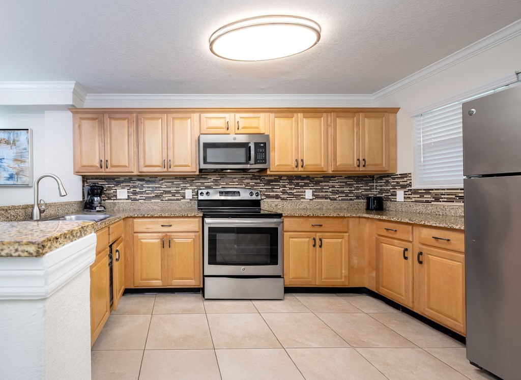 A kitchen with wooden cabinets and a granite countertop.