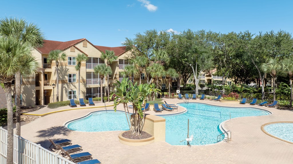 A large building with a pool in front of it.
