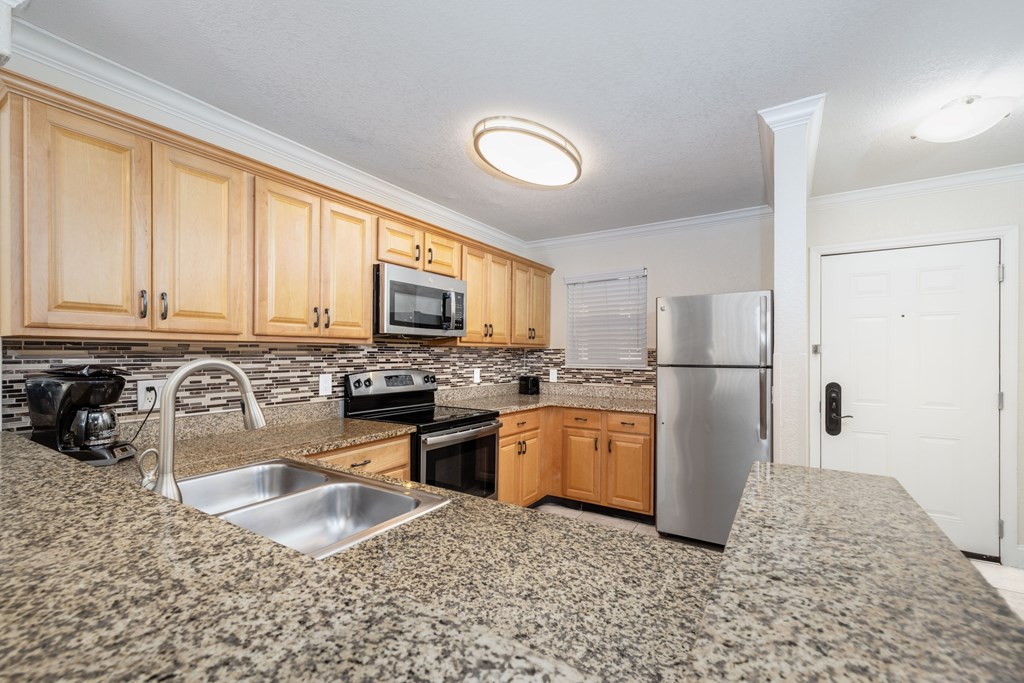 A kitchen with wooden cabinets and a granite countertop.