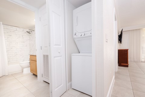 A white kitchen with a white oven and a white fridge.