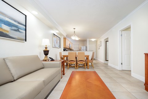 A living room with a couch, a dining table and chairs.