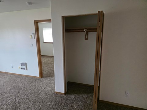 A room with a white wall and a brown door.