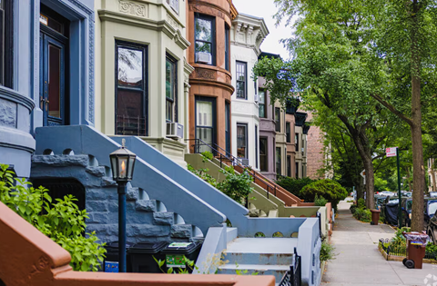 A row of houses with a tree in front of them.