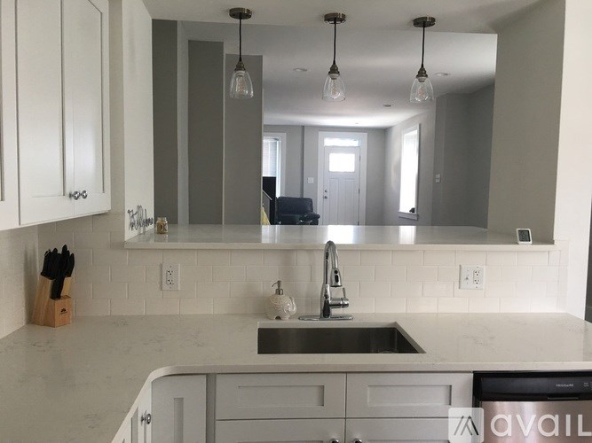A kitchen with white cabinets and a marble countertop.