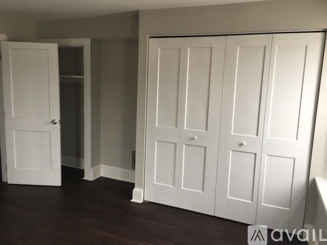 A room with white doors and a wooden floor.