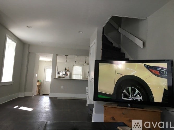 A living room with a television displaying an image of a car.