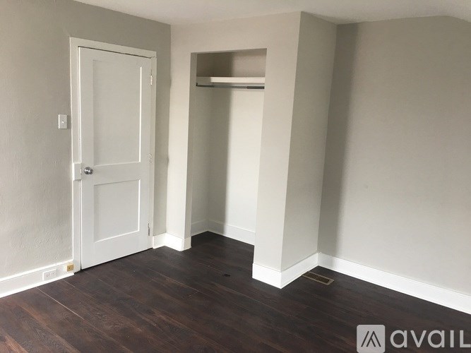 A room with a door and a small closet.