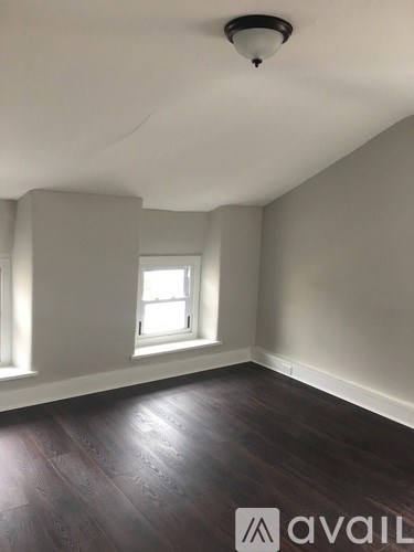 A room with a window and wooden flooring.