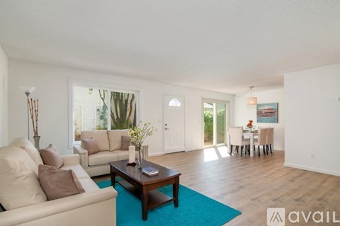 A living room with a blue rug and a brown coffee table.