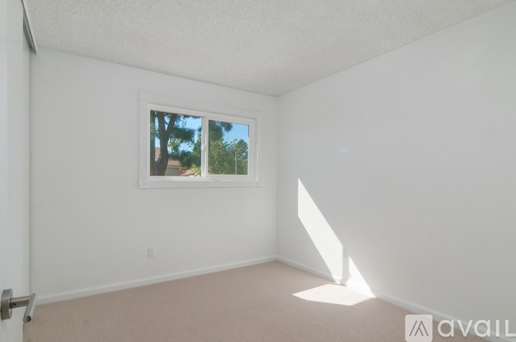 A room with a window and a white wall.