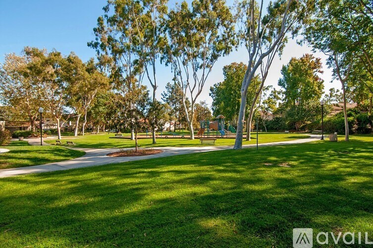 A park with a walking path and trees.