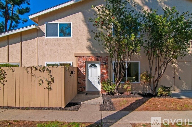 A house with a white door and a brown fence.
