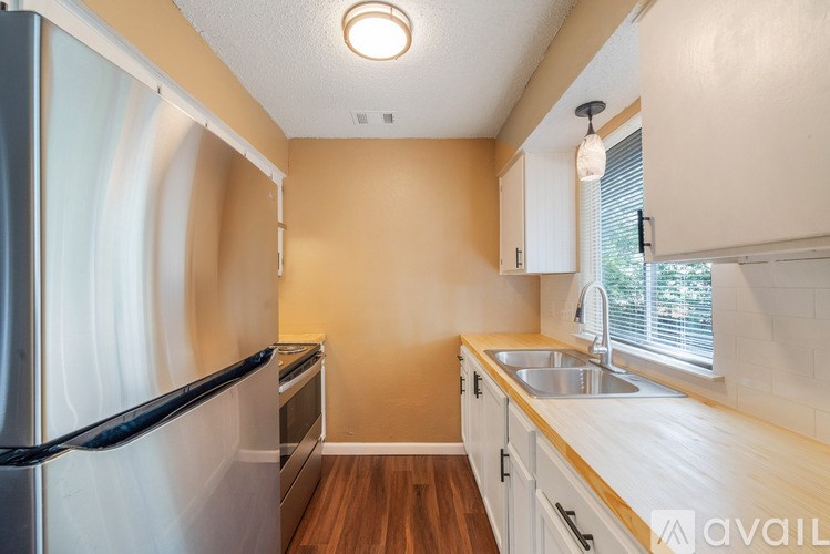 A kitchen with wooden floors and white appliances.