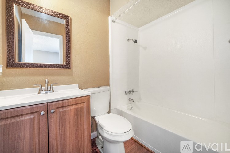 A bathroom with a toilet, sink, and mirror.