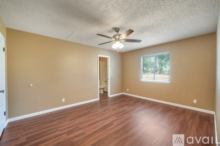 A room with a ceiling fan and a window.