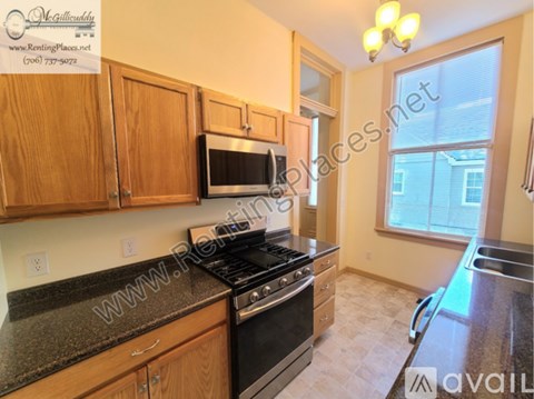 A kitchen with wooden cabinets and a black stove top oven.