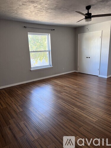 A room with wooden flooring and a ceiling fan.
