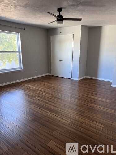 A room with wooden flooring and a ceiling fan.